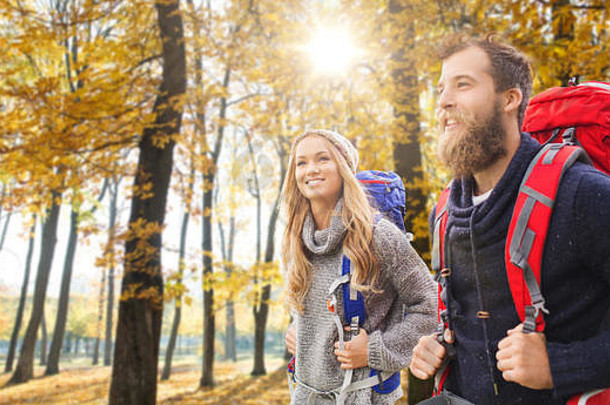 微笑的夫妇背着背包在秋天远足