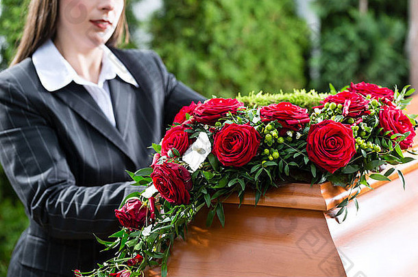 哀悼女人葬礼红色的玫瑰站棺材棺材