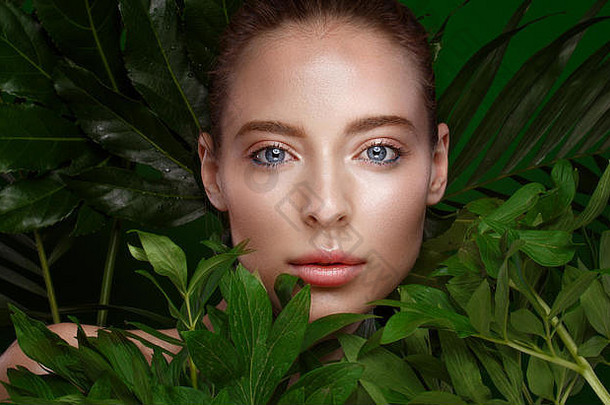 美丽的新鲜的女孩完美的皮肤自然化妆绿色叶子美脸