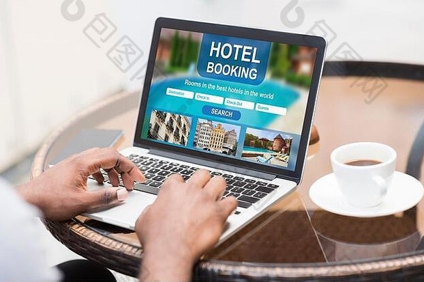 黑人在咖啡馆用笔记本电脑上网找酒店