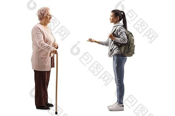 一名女学生用白色背景上的手杖与一名高年级妇女交谈的全长侧面照片