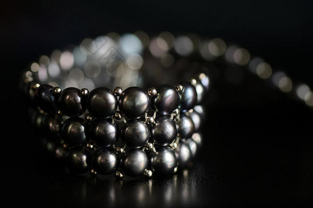 黑色珍珠项链，深色背景特写
