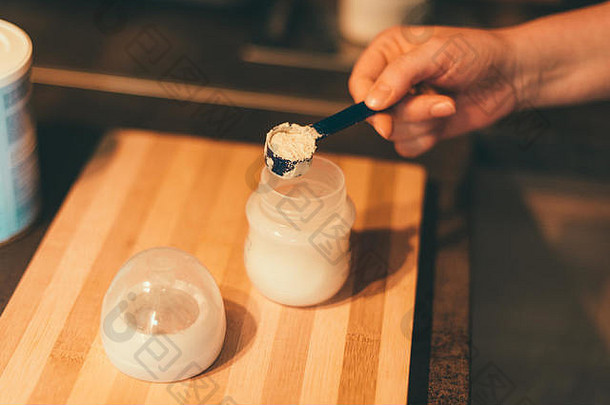 母亲在奶瓶中制作婴儿奶粉，用于新生儿喂养，手持式录像