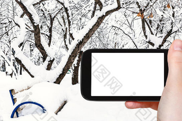 旅行概念<strong>旅游照片</strong>板凳上白雪覆盖的公共城市花园冬天莫斯科城市智能手机空断路屏幕