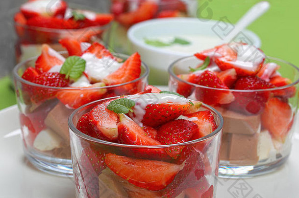 夏季酸奶甜点浇在新鲜成熟的草莓片和牛奶可可果冻<strong>慕斯</strong>上，俯瞰，特写