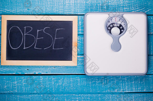 显示浴室秤和黑板上显示肥胖的减肥概念