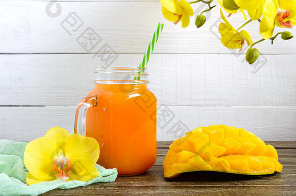 芒果奶昔玻璃Jar新鲜的芒果木背景芒果摇热带水果概念