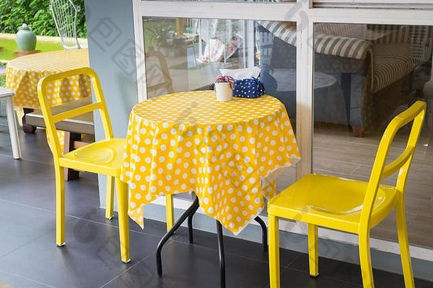 室外餐厅花园黄色桌椅，库存照片