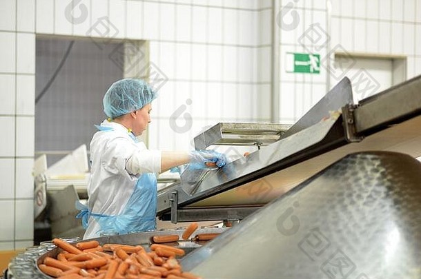 食品工业工作场所.生产香肠的屠宰厂.在装配线上工作的妇女