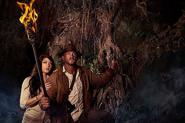 印第安纳·琼斯（Indiana Jones）在山洞里扮演一位手持火炬的冒险猎人