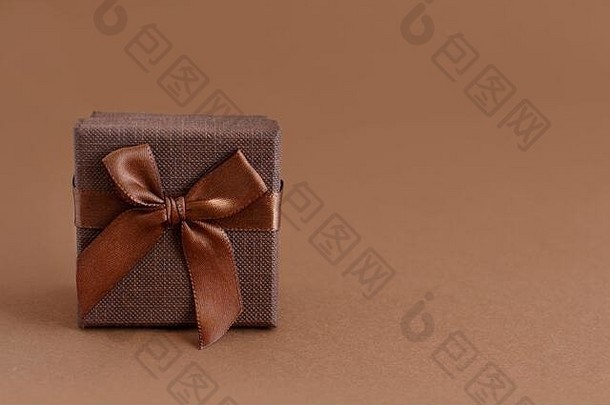 棕色背景特写带蝴蝶结的棕色礼品盒