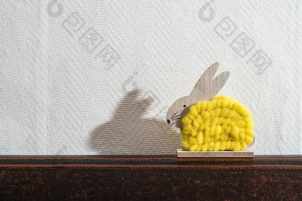 黄色的复活节兔子前面白色墙房间兔子装饰白色壁纸背景影子兔子墙木兔子变量