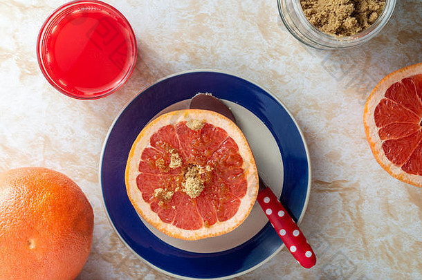 新鲜的葡萄柚和<strong>鲜榨果汁</strong>，红糖，健康早餐，放在一个浅色大理石桌面上