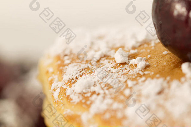 早餐薄煎饼，上面涂有樱桃和糖粉（糖粉），背景为白色。早餐的概念。健康饮食