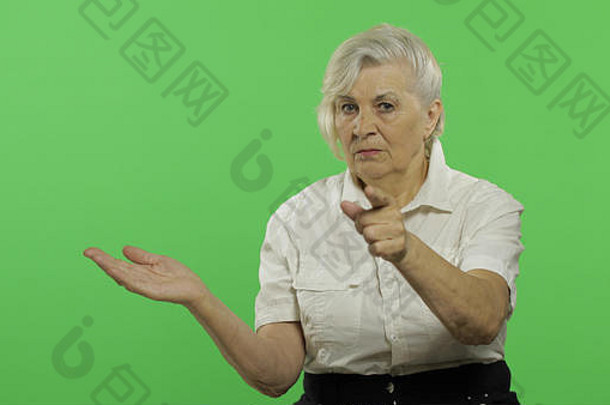 上了年纪的女人点相机微笑漂亮的祖母白色衬衫的地方标志文本浓度关键绿色屏幕背景
