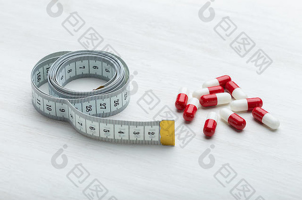 红色的白色饮食药片谎言白色表格测量磁带概念重量损失药物