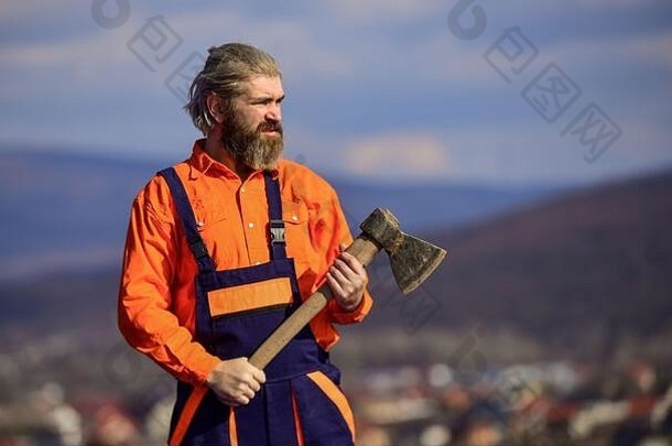 穿制服的留胡子的男人。成熟的建筑工人使用斧头。使用ax工具的专业维修工。建造和建造。熟练的架构师维修和修理。工程师职业。