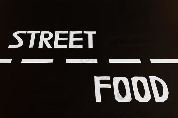 构成书面英语街头食物的白色字母位于道路的两条车道上