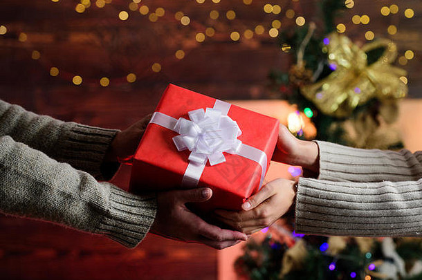 新年快到了。圣诞礼物。带着爱的礼物。男人给女人一个盒子。家庭价值观。彼此相爱。相爱的情侣之手。圣诞快乐。新年快乐。寒假周末。