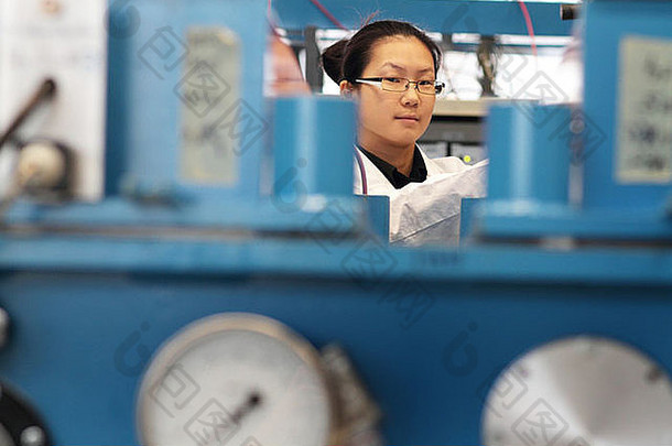 一位亚洲女科学家正在一个全息实验室里工作，她的无尘外套了新技术
