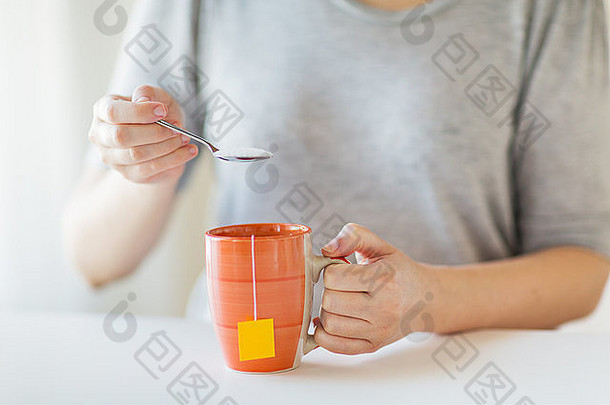 一个女人往茶杯里加糖的特写镜头