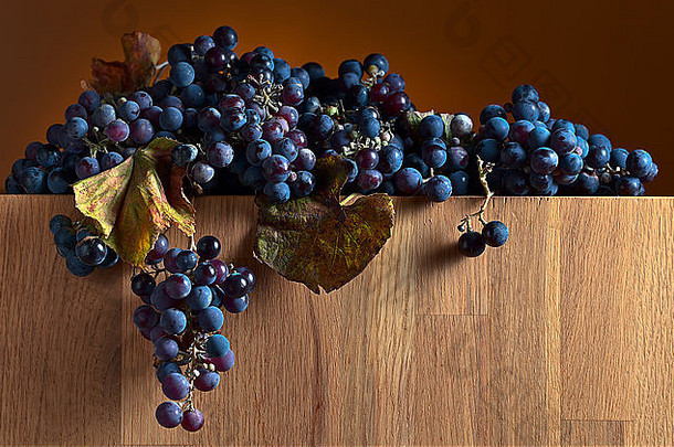 老木桌上有叶子的蓝葡萄
