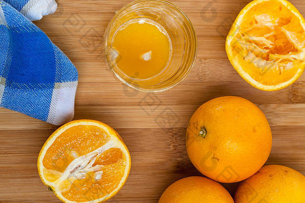 新鲜橙子和一杯<strong>果汁</strong>放在木板上，蓝色餐巾