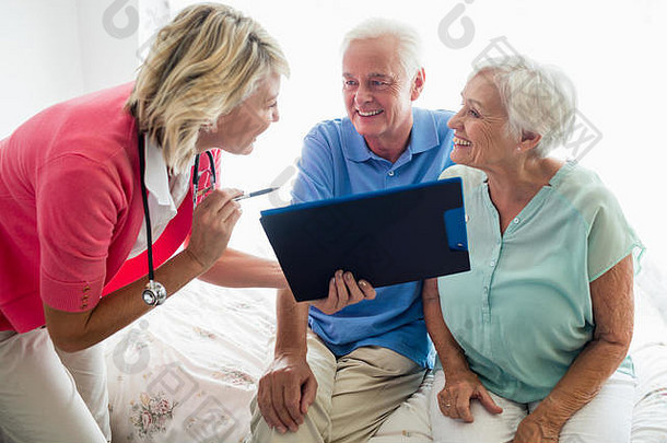 带剪贴板的老年夫妇和护士