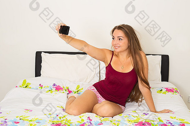 年轻的女人采取自拍卧室