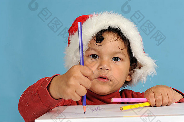 戴着圣诞帽写信的小男孩