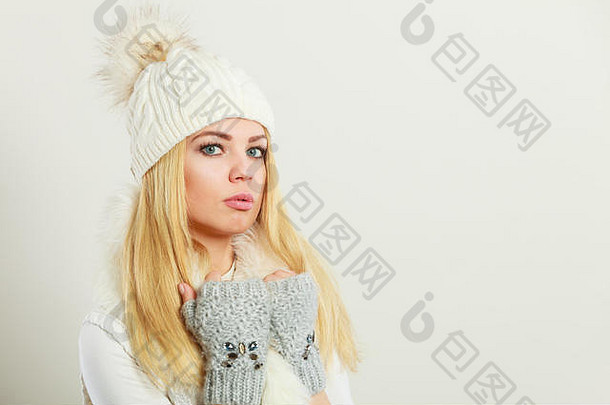 冬季时尚。年轻的金发女郎，穿着时尚的<strong>冬季服装</strong>，白色毛皮围巾，羊毛帽和手套，摄影棚拍摄