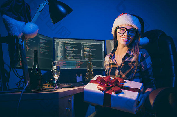 程序员女士工作到深夜迎接新年独自一人办公室工作狂手持大礼品盒最佳公司员工喝起泡酒穿圣诞老人