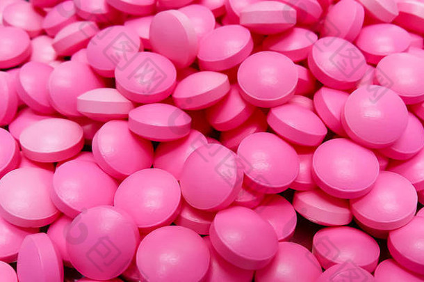 不锈钢药盘上的粉红色药物胶囊、粉红色药丸和抹刀