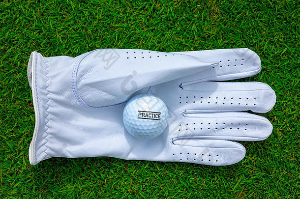 瑞士绿草上的高尔夫手套和高尔夫球。