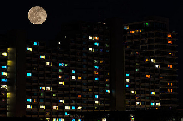 完整的月亮晚上天空色彩斑斓的照亮窗户住宅高上升公寓房子