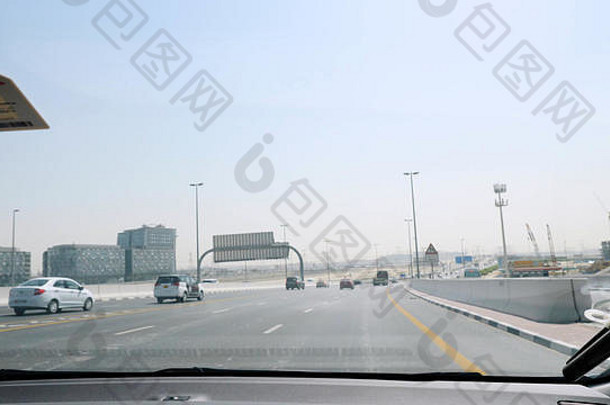 商人在迪拜开车旅行，可以看到汽车。从迪拜街道上的汽车内部可以看到，在一个炎热的日子里，一名男子驾驶着一辆汽车