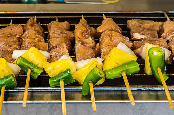 鸡肉沙爹串。，夜市上的亚洲美食，泰式烤肉和蔬菜。