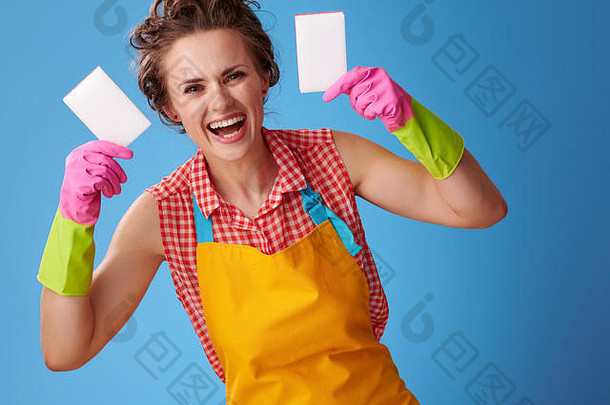 <strong>大扫除</strong>时间。戴着橡胶手套，露出厨房海绵的快乐年轻女子