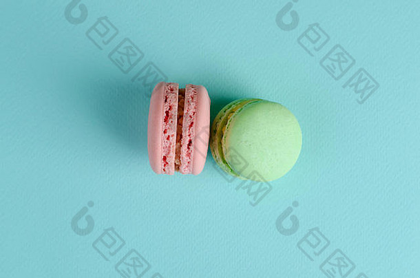 两种甜的法国甜点，<strong>淡绿</strong>色和粉红色，<strong>淡</strong>蓝色背景上有杏仁饼或杏仁饼。文本的空间。贺卡或请柬