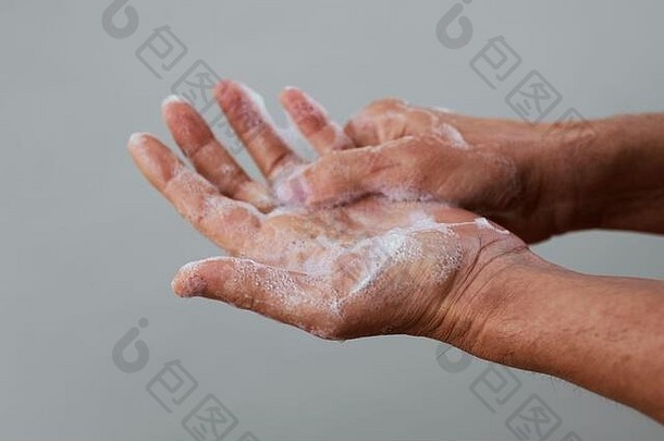 特写镜头高加索人男人。洗手肥皂苍白的灰色的背景