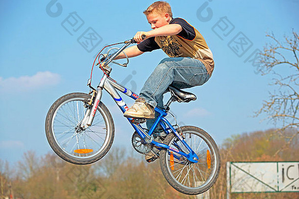 小男孩骑着自行车跳着