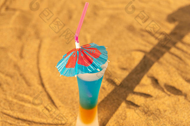 五颜六色的镜头带着雨伞在沙滩上畅饮，夏日放松