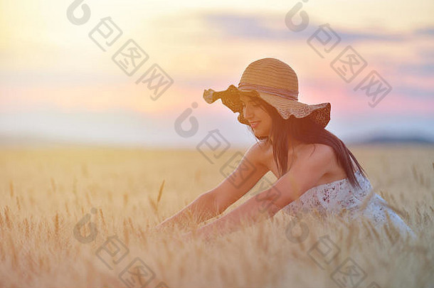 特写镜头肖像微笑年轻的高加索人女人自然快乐的年轻的美丽的女人触碰小麦场日落