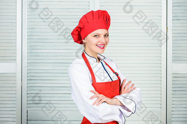 戴厨师帽和围裙的女人。厨房里的专业厨师。烹饪快乐女人用食谱烹饪健康食品。有厨具的家庭主妇。有用的技术。食物介绍。