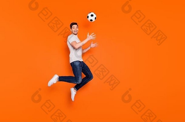 完整的身体配置文件照片有趣的的家伙跳高抓足球球上瘾风扇守门员穿条纹t恤牛仔裤运动鞋孤立的明亮的
