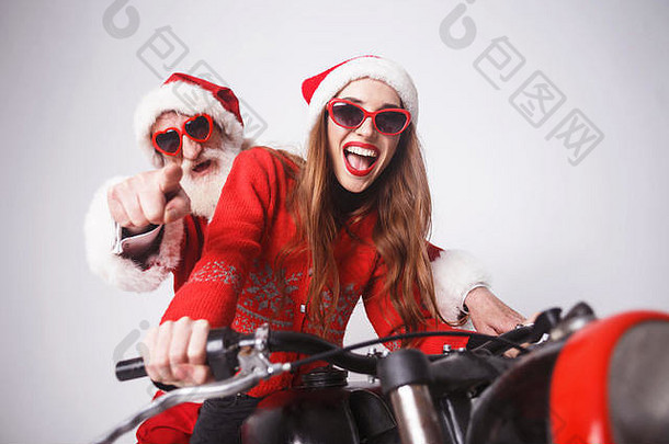 快乐年轻的夫人老人穿圣诞老人他红色的毛衣太阳镜坐着圣诞老人老人摩托车一年圣诞节假期记忆礼物<strong>购</strong>物折扣商店雪少女圣诞老人老人化妆发型<strong>狂欢</strong>节