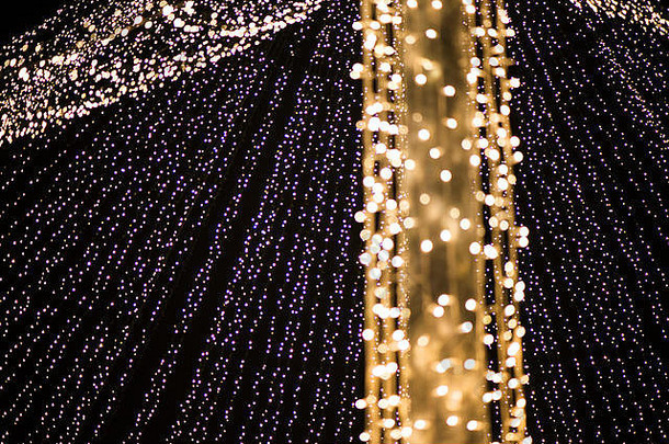 抽象圣诞树，色彩鲜艳，背景模糊。圣诞集市的市中心灯火通明