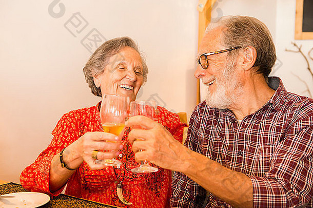 一对老夫妇在餐馆里干杯，看上去很开心