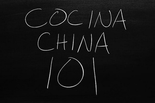 黑板上用粉笔写着“Comida China 101”。翻译：中国食物101