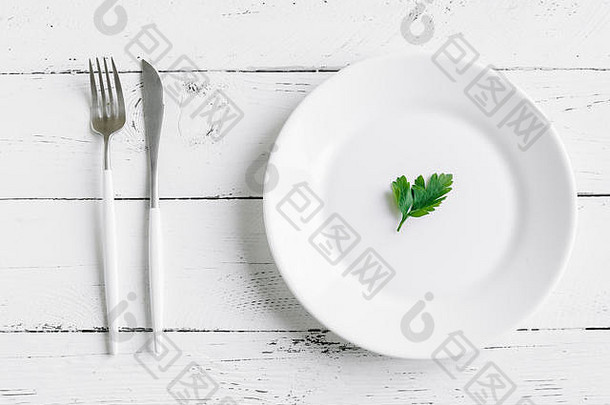 表格设置白色板现代餐具叉刀叶新鲜的欧芹白色背景前视图复制空间饮食快